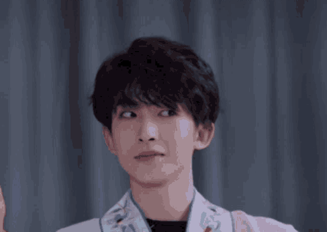 a young man making a funny face while wearing a pink jacket