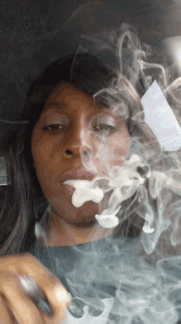 a woman smoking a cigarette with smoke coming out of her nose