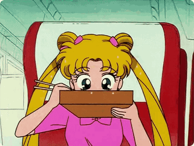 a girl in a pink shirt is sitting in a chair eating noodles with chopsticks
