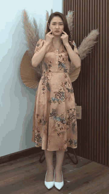 a woman in a floral dress making a face