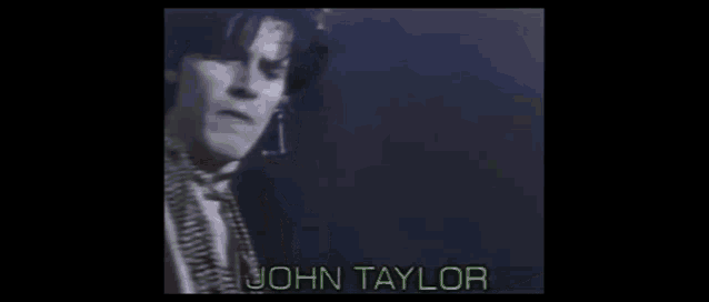 a close up of a person 's face with the name john taylor written on the bottom .