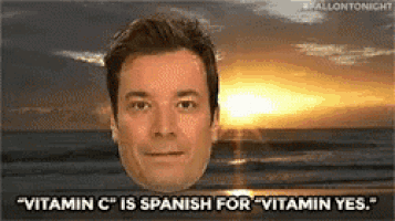 a man is standing on a beach with the sun shining through the clouds .