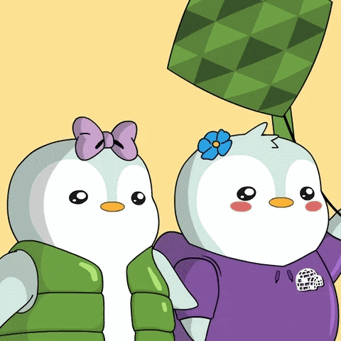 a couple of penguins standing next to each other with one wearing a green vest