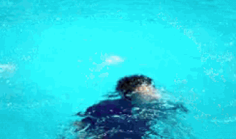 a person is swimming in a pool and making a lot of splashes .