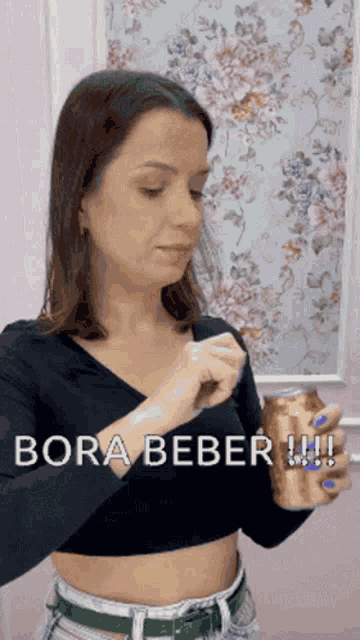 a woman in a black crop top is holding a can and says bora beber !!!
