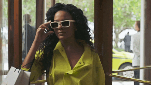 a woman wearing white sunglasses and a yellow shirt