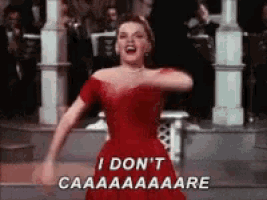 a woman in a red dress is singing and says i don 't caaaaaare