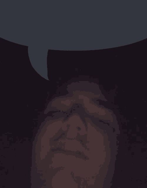 a close up of a man 's face with a speech bubble behind him