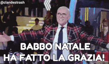 a man in a plaid suit and tie is standing in front of a crowd and says babbo natale ha fatto la grazia