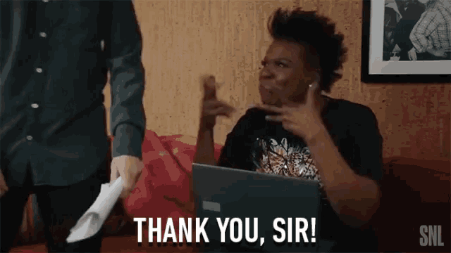 a woman sitting in front of a laptop is saying thank you sir