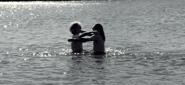 a man and a woman are hugging in a body of water