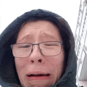 a close up of a person wearing glasses and a hood .