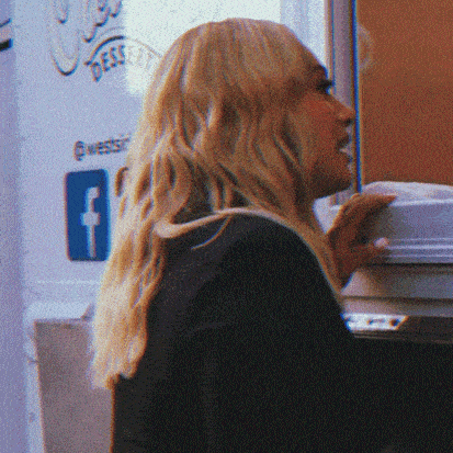 a woman stands in front of a sign that says dessert on it