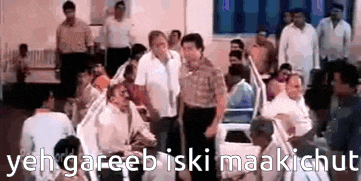 a group of people are standing in a room with the words `` yeh gareeb iski maakichut '' written on the bottom .