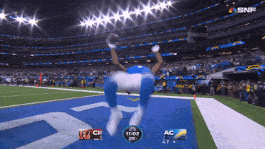 a football player is jumping in the air during a game with snf