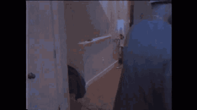 a man in a suit and hat is standing in a bathroom in a dark room .