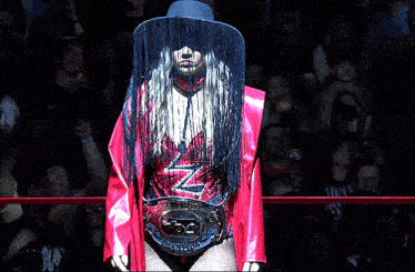 a woman wearing a cowboy hat and a belt that says ' tna ' on it