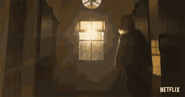 a woman is walking down a hallway with a netflix logo in the corner