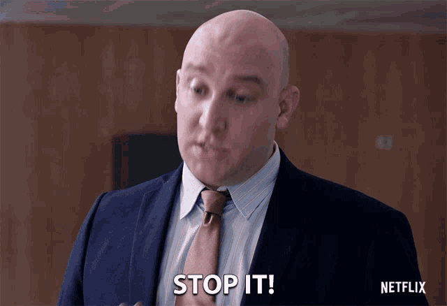 a man in a suit and tie is saying stop it