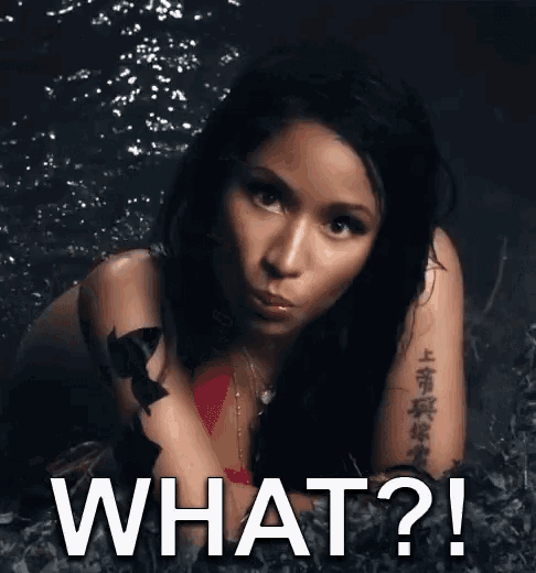 a woman with a tattoo on her arm is laying in the grass with the words what ?
