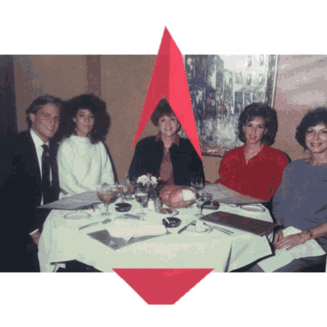 a group of people sit at a table with a red arrow pointing to the left