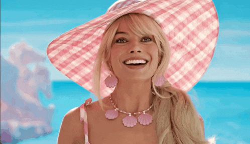 a woman wearing a pink hat and a necklace with seashells