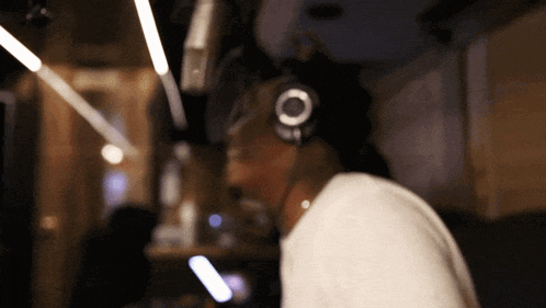 a man wearing headphones and a white shirt looks down