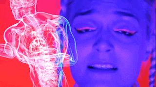 a woman is crying with a skeleton of a man behind her .