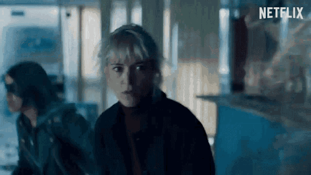 a woman in a dark room with a netflix logo on the bottom right