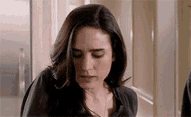 a close up of a woman 's face with her eyes closed and a serious look on her face .