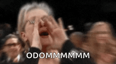 a woman is crying in a crowd of people while holding her hands to her face .