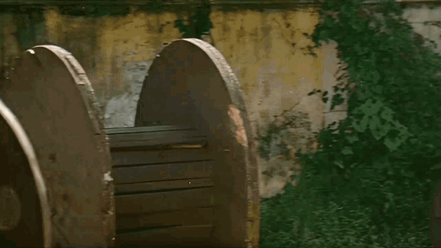 a man in a plaid shirt is running in front of a brick wall