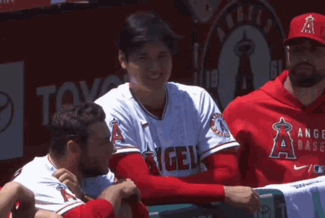a baseball player with the number 7 on his back talks to another player
