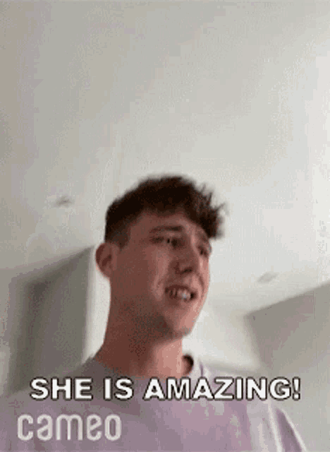 a man is standing in a room with the words `` she is amazing ! cameo '' written on the bottom .