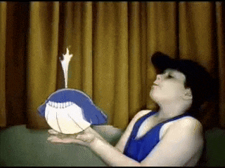 a person blowing out a candle on a blue bird
