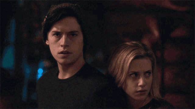 a man and a woman are standing next to each other and looking at something