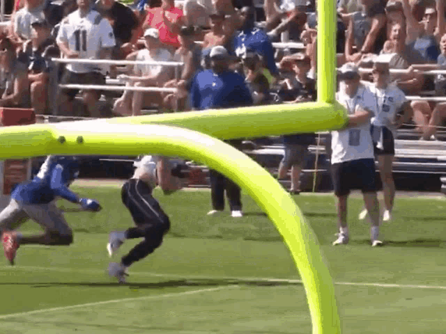a football player wearing a number 11 jersey is running towards the goal line