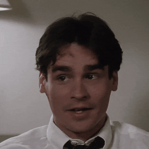 a close up of a man 's face with a white shirt and tie