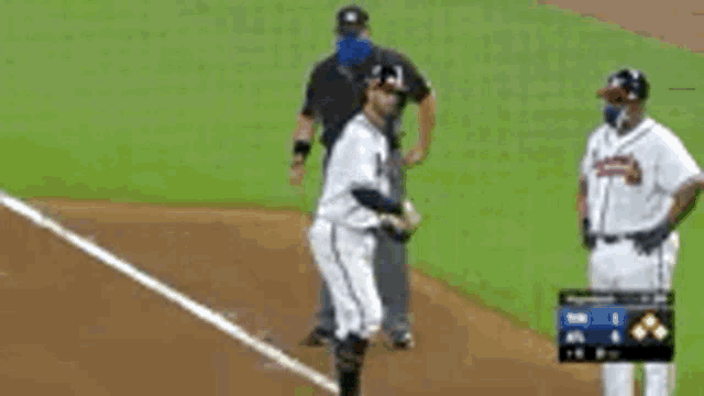 a baseball player is standing on a field with a referee .