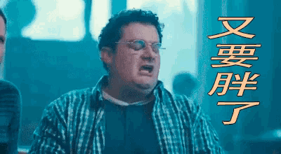 a man wearing glasses and a plaid shirt with chinese writing on the bottom