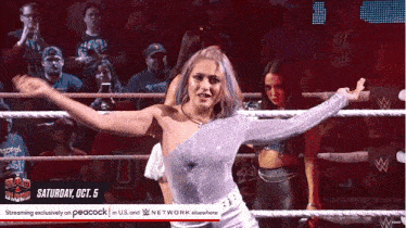 a woman in a wrestling ring with a peacock advertisement behind her