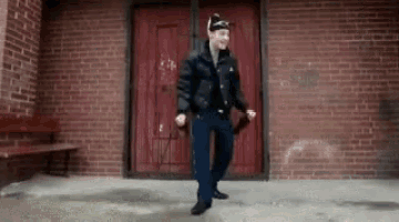 a man is dancing in front of a red door .