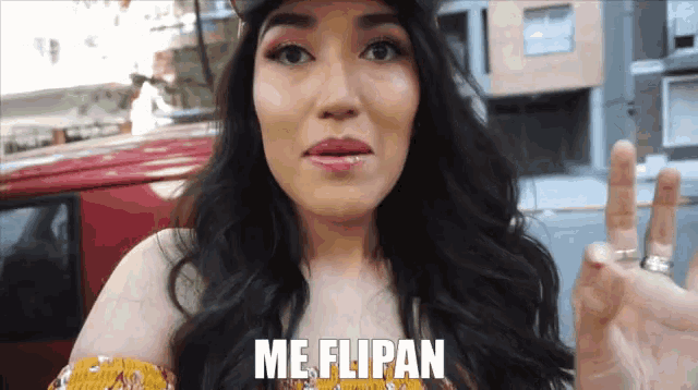 a woman says me flipan while making a peace sign