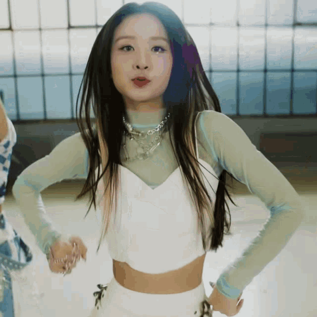 a woman with long hair is wearing a white crop top and white shorts