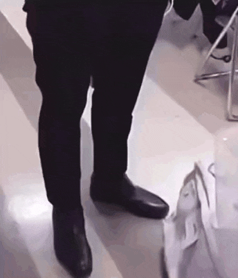 a close up of a person 's feet wearing black shoes and a suit .
