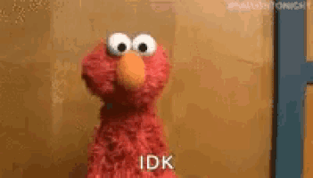elmo from sesame street is standing in front of a wooden wall and says `` idk '' .