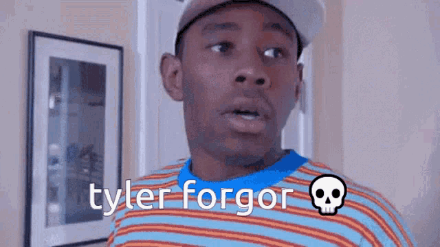a man wearing a striped shirt and a hat with the name tyler forgor written on it