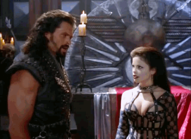a man and a woman standing next to each other in a room with candles .