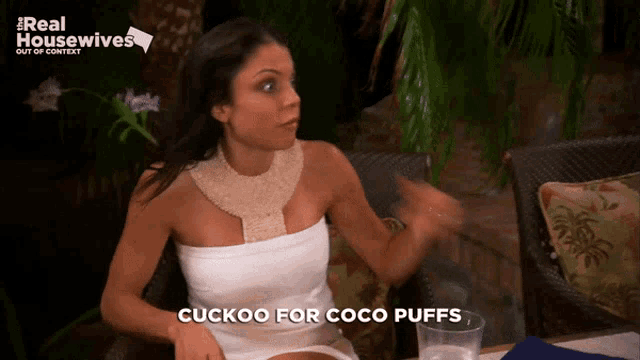 a woman says cuckoo for coco puffs while sitting at a table with a glass of water