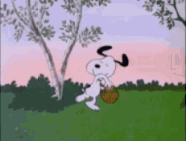 snoopy is holding a basket in a field